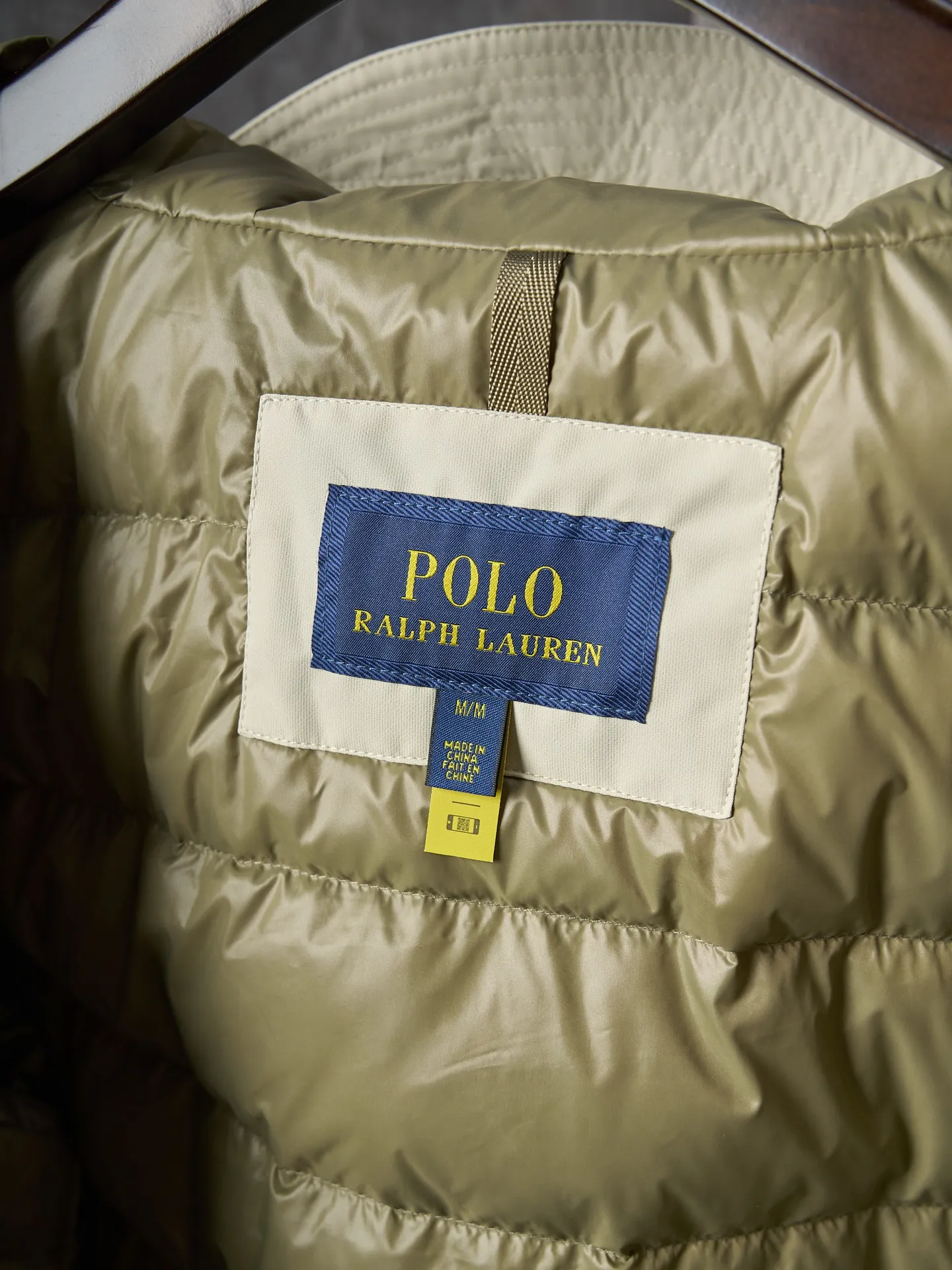 P980 Actual auction】Ralph Lauren/Ralph Lauren pony embroidered zipper hooded down jacket [Ready stock] S M L XL high-quality filling: 90 white duck down is selected, weighing 220g, ensuring excellent thermal insulation performance. After strict screening and processing, the velvet is not easy to be drilled, ensuring durability. The density of high-density nylon taffeta is about 210T-300T, with a smooth and slightly matte surface, excellent windproof and waterproof properties (with DWR water-repellent treatment), strong wrinkle resistance and easy care, in line with the positioning of American casual "durable and practical".  The inner lining is made of 100% polyamide. The high-density and tight weaving process prevents fine lint from getting out of the gaps in the fabric. The smooth surface improves the putting on and taking off experience, and the excellent wear and tear resistance ensures damage caused by frequent use, while the light and soft texture does not affect the overall weight.  The classic jacket has a slightly loose fit, slightly dropped shoulder line (shoulder width is 1-2cm wider than the standard fit), is hip-length, and has slightly tapered straight sleeves, taking into account both freedom of movement and casual style.  The adjustable Velcro on the cuffs allows you to freely adjust the tightness according to the thickness of your wrist and personal preferences, effectively preventing cold wind from intruding, and improving the warmth performance.  In terms of storage, the two front zipper pockets are convenient for you to place frequently used items, and the zipper design ensures that items are not easily lost. A built-in pocket on the left side of the chest provides a safe storage space for some small private items.  The drawstring design at the hem allows you to adjust the shape of the jacket according to your body shape and dressing needs. Whether it is loose and casual or slim and neat, you can easily control it.  Embroidery technology: Polo horse logo on the left chest: flat satin stitch embroidery (satin embroidery), embroidery thread: 100% polyester high color fastness embroidery thread (the color number is consistent with the brand’s standard red color card), stitch density 12-15 stitches/cm, the outline of the horse logo is clear, and the details of the rider and horse are burr-free.  Embroidery positioning: precise positioning through the template (12cm from the neckline and 8cm from the placket) to ensure left and right symmetry and centering.